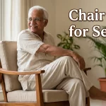 An elderly Indian man sitting on a chair comfortably smiling, looking flexible and happy. Text overlay: Chair Yoga for Seniors